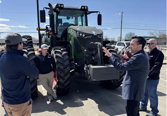 Delta Ag Equipment team member showcasing a Fendt tractor during an outdoor event.